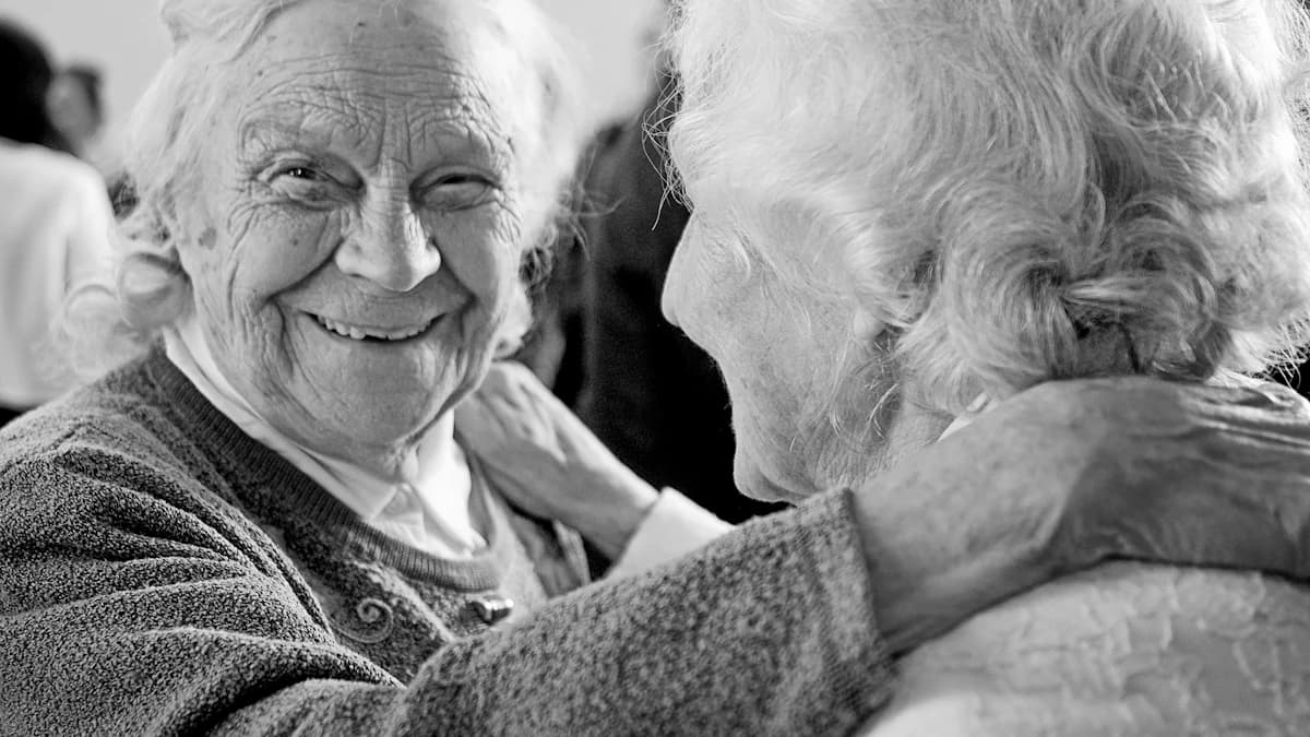 Oudere deelnemer doet mee aan dagbesteding in een begeleide groep