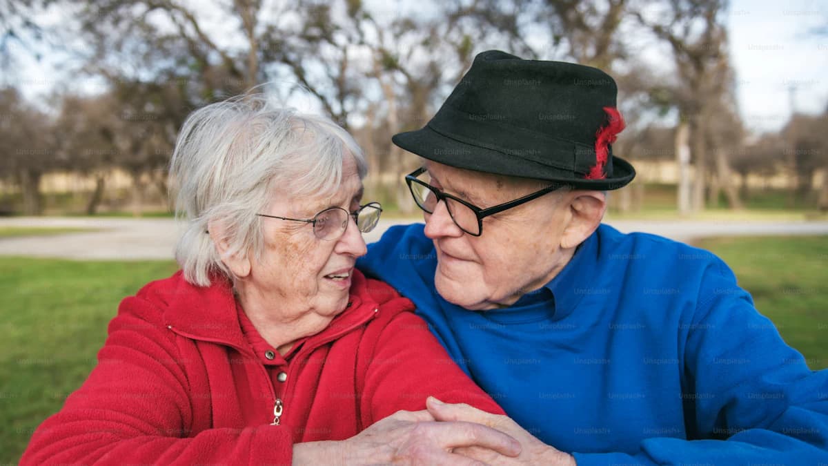 Oudere met dementie en mantelzorger bespreken dagopvang met begeleider