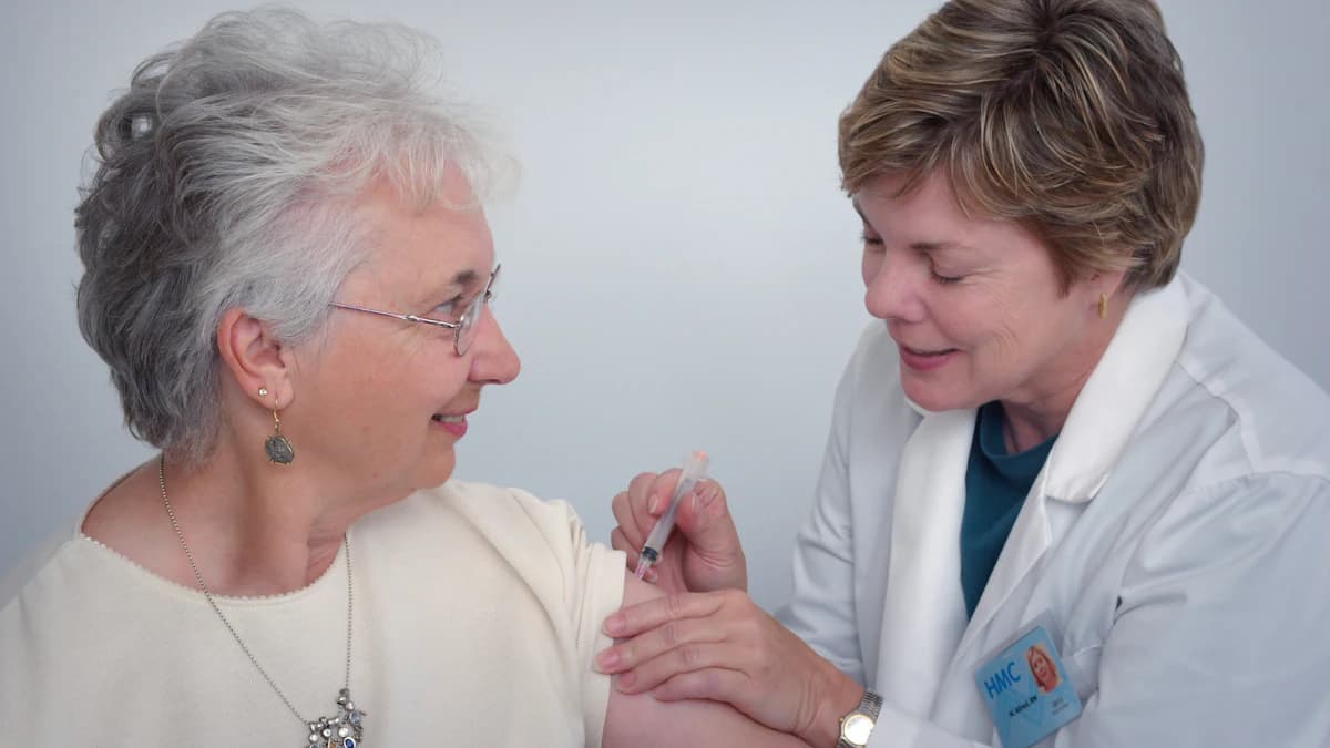 Geriater bespreekt medicatielijst met oudere patient en mantelzorger