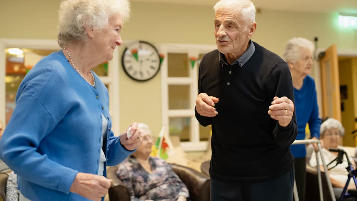 Geriatriefysiotherapeut begeleidt oudere met neurologische kwetsbaarheid bij lopen