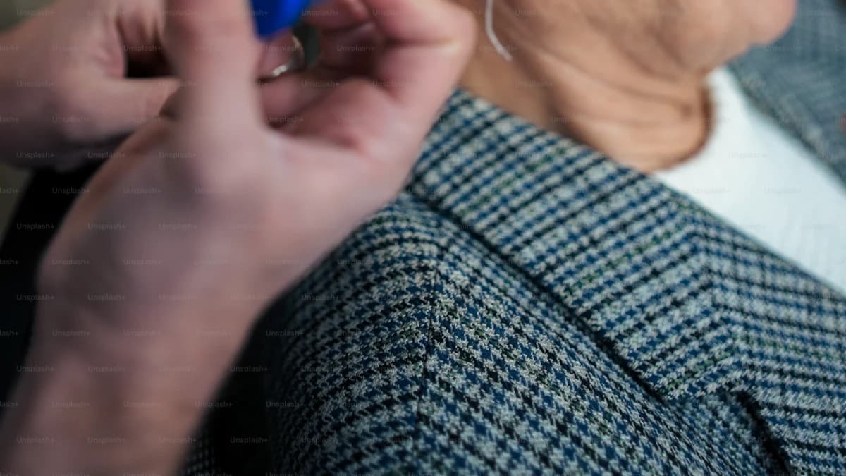 Persoon krijgt uitleg over oordoppen op maat in een hoorwinkel