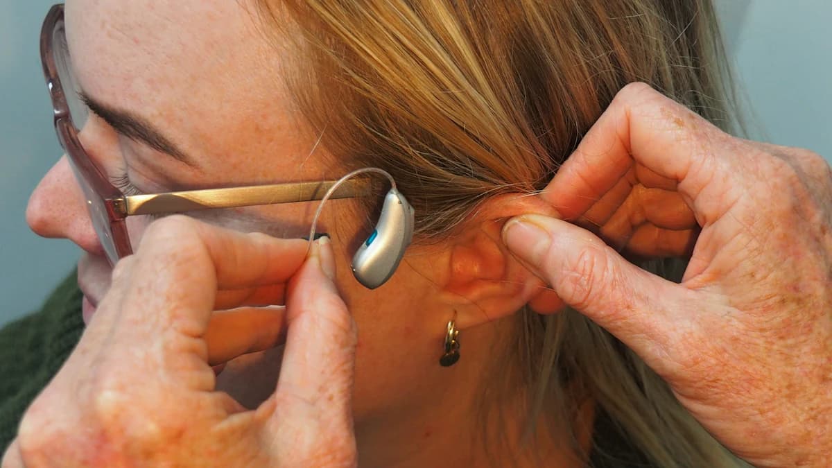 Volwassen kind bespreekt gehoorverlies rustig met ouder